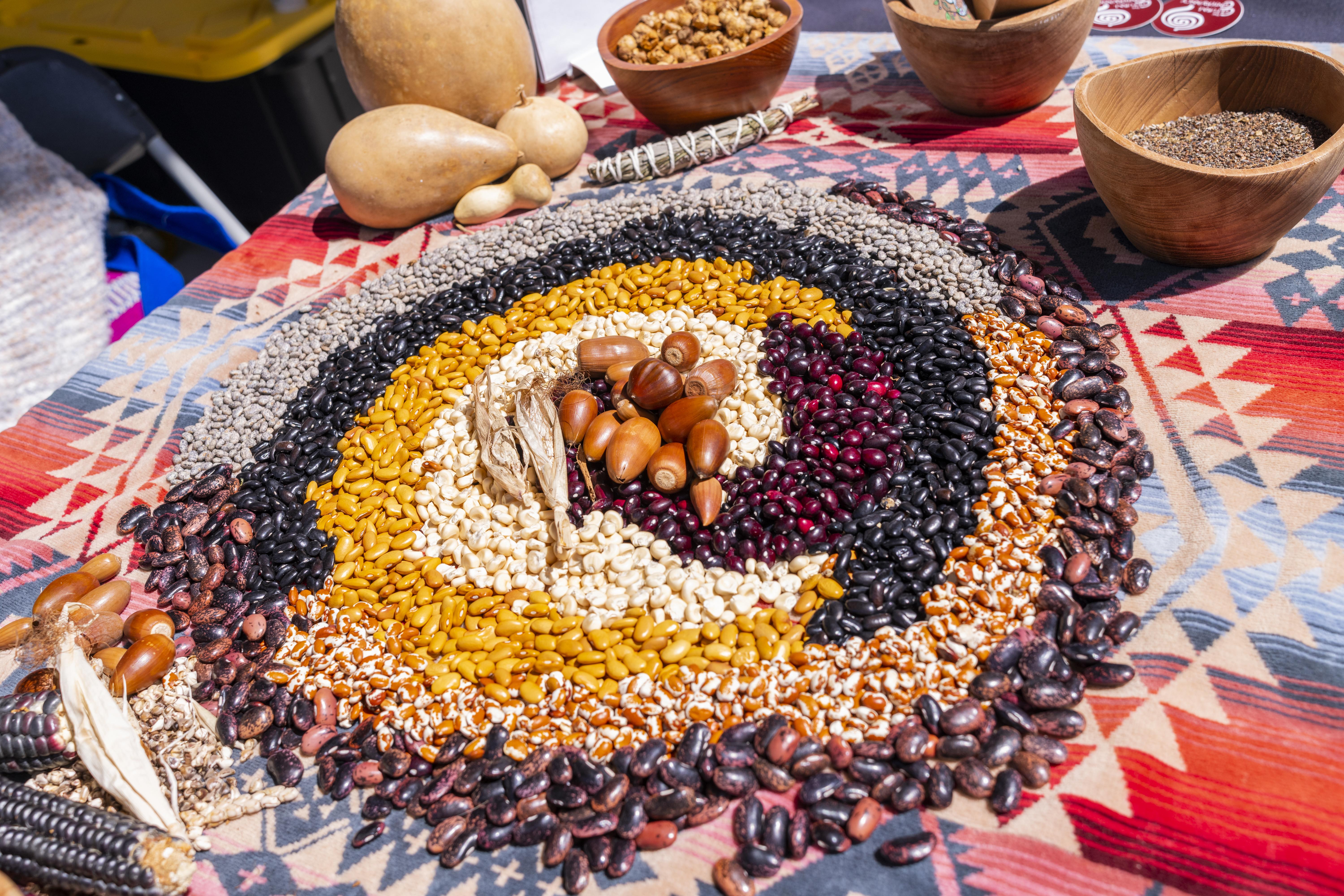 Assorted Various Colored Beans laid out on a table in a swirl pattern by color